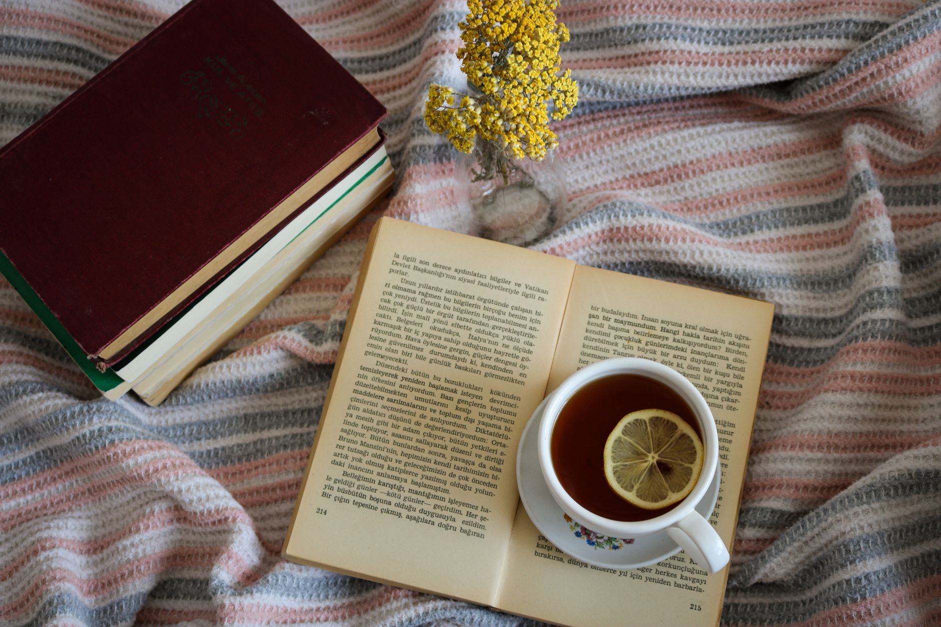 Açık bir kitap ve yanında limonlu çay